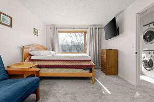 1 dormitorio con 1 cama y lavadora en Moose Meadows- Near the airport, centrally located, en Anchorage
