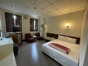 a bedroom with a bed and a desk and a television at New Bright Hotel in Zhunan