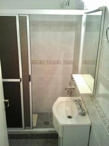 y baño blanco con lavabo y ducha. en Chivilvoy en Mar del Plata