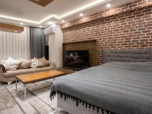 una camera da letto con un muro di mattoni, un letto e un divano di Apartment right next to the CevahirShopping Center a Istanbul