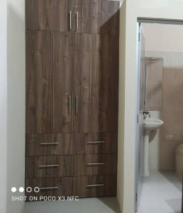 - une armoire en bois dans la salle de bains pourvue d'un lavabo dans l'établissement Casa amoblada y cómoda en BALLENITA, Santa Elena., à Ballenita