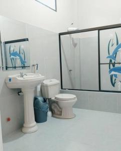 een witte badkamer met een wastafel en een toilet bij Casa amoblada y cómoda en BALLENITA, Santa Elena. in Ballenita