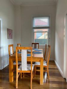a dining room table and chairs with a table and a window at Central CBD House in Wagga Wagga