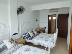- une chambre avec 2 lits et un bureau avec un ventilateur dans l'établissement PD Paradise Lagoon Apartment North B-2-6, à Port Dickson