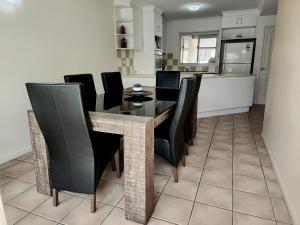 una sala da pranzo con un tavolo e sedie nere di La Villa Pets ok No pet without Calling host prior to booking t&C apply ad Airlie Beach Altre 13 foto