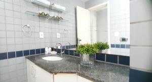 W łazience znajduje się umywalka i lustro. w obiekcie Apartamento Aconchego na Praia da Costa w mieście Vila Velha