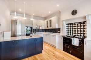a large kitchen with white cabinets and blue appliances at Hilltop At Hawkshead Hill in Ambleside