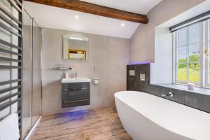 a bathroom with a tub and a sink and a window at Hilltop At Hawkshead Hill in Ambleside +26 photos