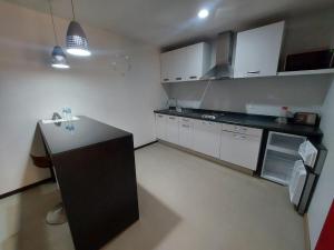 a kitchen with white cabinets and a black counter top at Capital Luxury Apartments & Offices in Mexico City
