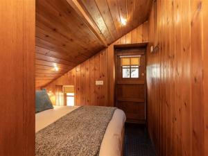 a bedroom with a bed in a wooden cabin at Dovecot Cottage in Ambleside