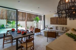 a living room with a table and chairs and a couch at Unho Tulum in Tulum