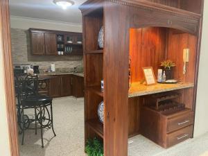 a kitchen with wooden cabinets and a counter with a table at MView: Comfortable, great location, city view in Santiago de los Caballeros