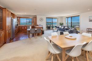 a kitchen and living room with a table and chairs at Shoreline 7 with 180 degree water views in Tuncurry