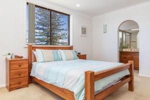 a bedroom with a bed and a large window at Shoreline 7 with 180 degree water views in Tuncurry