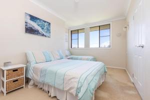 a bedroom with a bed and a window at Shoreline 7 in Tuncurry