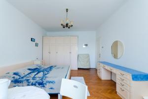 a bedroom with a bed and a desk and chairs at Rooms Sonja P in Rab