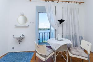 a dining room with a table and a sink and a window at Rooms Sonja P in Rab