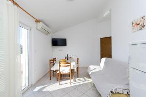 a dining room with a table and a chair at Apartments Marija P Lopar in Lopar