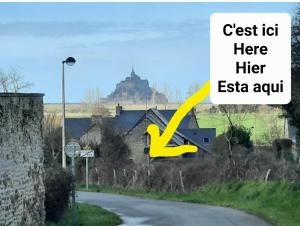 een huis op een weg met een heuvel op de achtergrond bij Le Pélican in Huisnes-sur-Mer