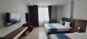 une chambre d'hôtel avec deux lits et une télévision à écran plat dans l'établissement Minh Hưng Motel, à Hạ Long 17 autres photos