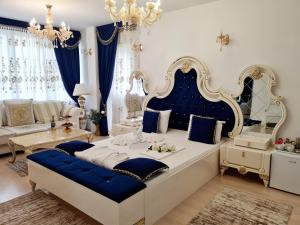 Hotel Dalia - Bankya في بانكيا: غرفة نوم بسرير كبير واثاث ازرق وابيض