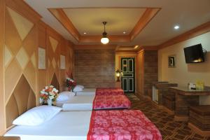 una camera d'albergo con due letti e una televisione di โรงแรมกู๊ดเรสซิเดนซ์ - Good Residence a Nong Khae