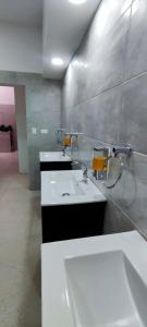 baño con 2 lavabos blancos en una habitación en Casa Baruch, en Bogotá