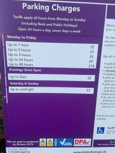 a sign for a parking garage with purple and white at High vibes home in Chelmsford
