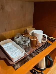a tray with cups and mugs on a table at Oemah Batur in Kintamani