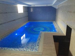 a swimming pool with blue water in a building at Chernivtsi Apartments in Chernivtsi