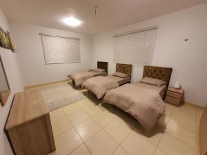 ein Schlafzimmer mit 2 Betten und einem Tisch darin in der Unterkunft فيلا الراحة in Al Qunfudhah