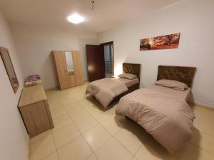 Zimmer mit 2 Betten und einem Spiegel in der Unterkunft فيلا الراحة in Al Qunfudhah