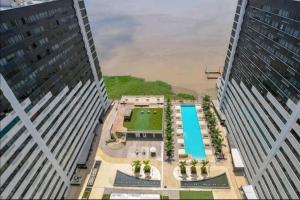 una vista aérea de un edificio con piscina entre dos edificios altos en Habitacion Piso 9 Vista Río Santa Ana AirportGYE, en Guayaquil