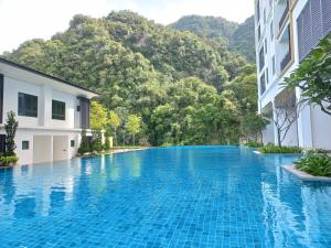 una piscina frente a un edificio con montaña en Sunway Onsen Studio @ Lost World of Tambun en Ipoh