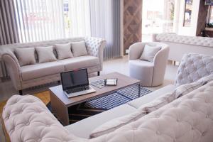 a living room with a couch and a laptop on a coffee table at Liebling Hotel Ciudad del Este in Ciudad del Este