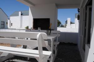 a white table and chairs on a patio at Quay West in Velddrif