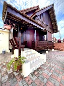 a house with a porch and stairs in front of it at Rumah Rehat Anjung Melayu Muslim in Melaka