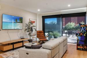 a living room with a couch and a tv on the wall at Retreat on Bellerine I Corporate or Getaway in Geelong