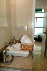 - Baño con lavabo y cesta en la encimera en Departamento Familiar Riverfront, en Guayaquil