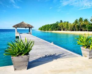 a dock with a gazebo on a beach at Paradisola in Fodhdhoo