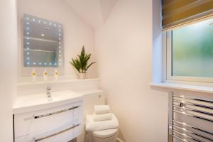 Un baño con lavabo, inodoro y ventana. en Lexington House, en Bowness-on-Windermere 23 fotos más