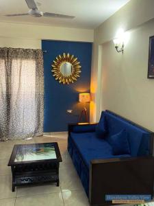 a living room with a blue couch and a table at Himalayan Valley View - A boutique homestay in Dehradun