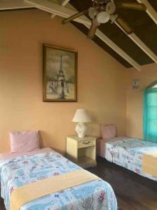 1 dormitorio con 2 camas y una foto en la pared en Villa Brisa Marina, en Tela