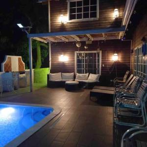 a patio with a couch and a pool at night at Villa Brisa Marina in Tela