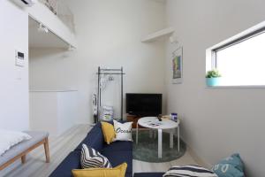 a living room with a blue couch and a table at Shibuya-ku - Apartment / Vacation STAY 1130 in Tokyo