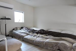 two beds in a room with white walls at Shibuya-ku - Apartment / Vacation STAY 1130 in Tokyo