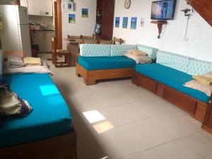 Sala de estar con 2 sofás azules y TV en Apartamentos en San Andres a 1 Cuadra de la Playa en el Centro, en San Andrés