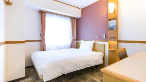 川崎市にある東横INN川崎駅前砂子のベッドと窓が備わる小さな客室です。