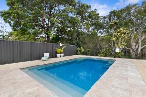 a swimming pool in a backyard with a fence at The Shack in Woorim