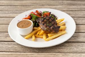 einen Teller mit einem Steak und Pommes frites in der Unterkunft Crown Hotel Surry Hills in Sydney